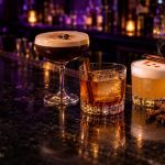 Chai espresso martini, apple butter old fashioned and smoked cinnamon whiskey sour on a dark bar